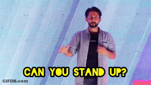 A Man Stands In Front Of A Screen With The Words Can You Stand Up GIF