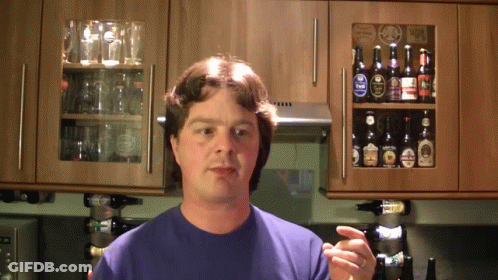 A Man Stands In Front Of A Shelf Full Of Beer GIF