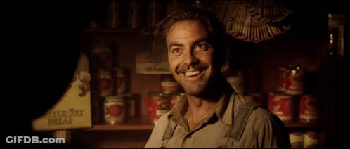 A Man Stands In Front Of A Shelf With Butter Nut Bread Cans On It GIF