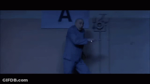 A Man Stands In Front Of A Sign That Says A GIF