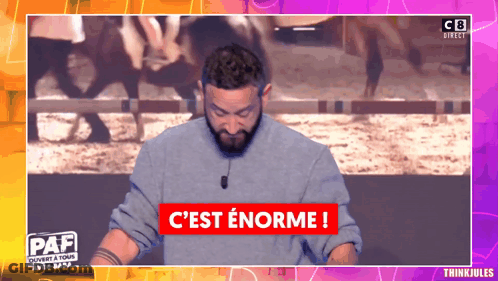 A Man Stands In Front Of A Sign That Says C Est Enorme GIF