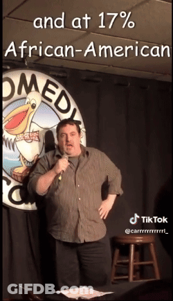 Man Standing In Front Of Comedy Club Sign GIF