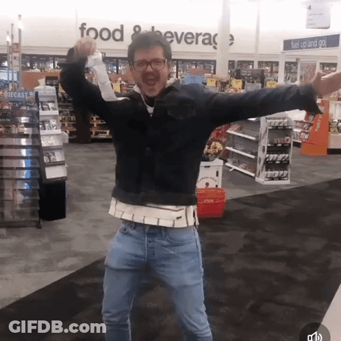 A Man Stands In Front Of A Sign That Says Food And Beverage GIF