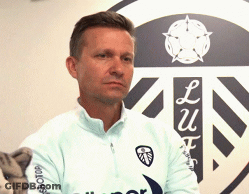 A Man Stands In Front Of A Sign That Says ' Lu ' On It GIF