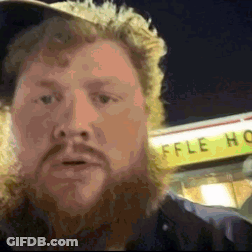 A Man Stands In Front Of A Sign That Says Waffle House GIF