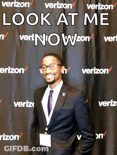 A Man Stands In Front Of A Verizon Banner GIF