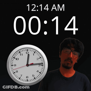 A Man Stands In Front Of A Wall Clock That Says 12:14 Am GIF