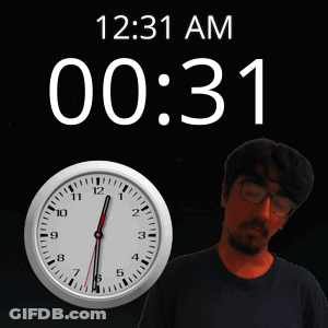 A Man Stands In Front Of A Wall Clock That Says 12:31 Am GIF