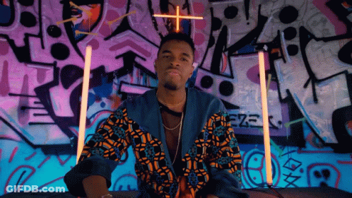 A Man Stands In Front Of A Wall That Has Graffiti On It And The Word Eze On It GIF