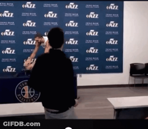 A Man Stands In Front Of A Wall That Has Jazz Written On It GIF