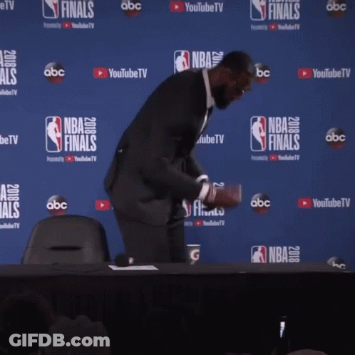 A Man Stands In Front Of A Wall That Says Nba Finals On It GIF