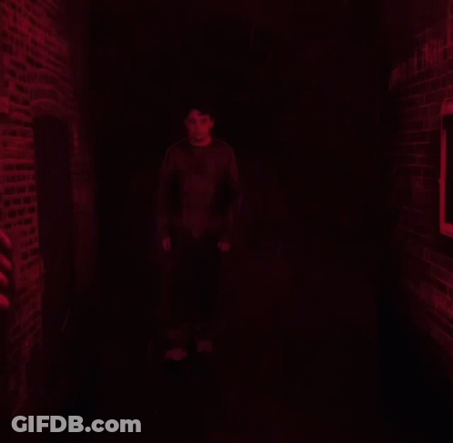 A Man Stands In Front Of A Wall That Says Unmask The Truth On It GIF