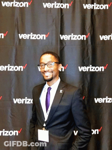 A Man Stands In Front Of A Wall That Says Verizon GIF