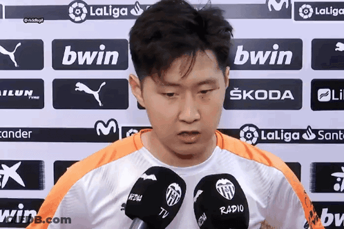 A Man Stands In Front Of A Wall With Bwin Logos On It GIF