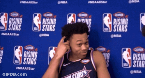A Man Stands In Front Of A Wall With Logos For Rising Stars GIF