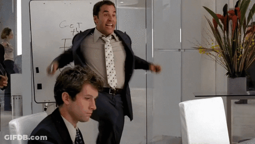 A Man Stands In Front Of A White Board That Says Get The GIF