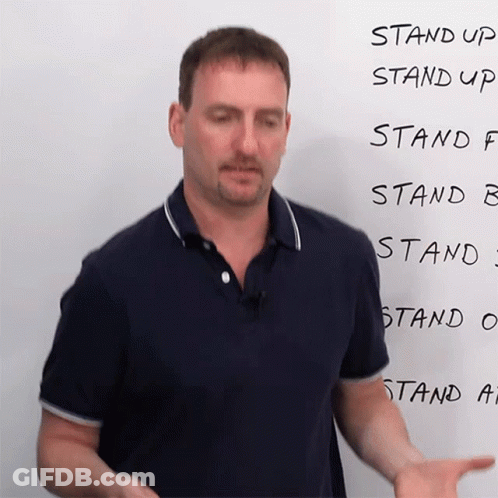 A Man Stands In Front Of A White Board That Says Stand Up Stand Up Stand F Stand B Stand C Stand O And Stand A GIF