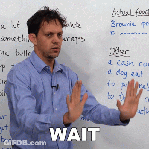 A Man Stands In Front Of A Whiteboard With The Word Wait Written On It GIF