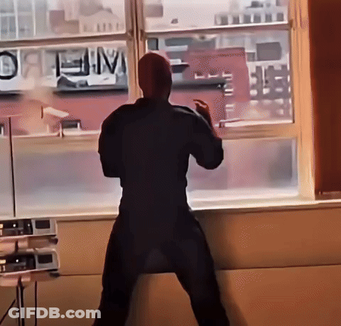 A Man Stands In Front Of A Window With A Sign That Says " Open " GIF