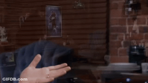A Man Stands In Front Of An Atari Machine In A Room GIF