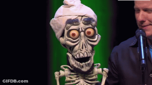 A Man Stands Next To A Skeleton Wearing A Turban GIF