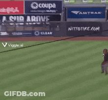 A Man Stands On A Baseball Field With A Sign That Says Coupa On It GIF