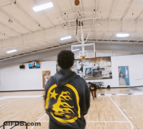 A Man Stands On A Basketball Court Wearing A Hoodie With Flames On It And The Number 71 On The Back GIF