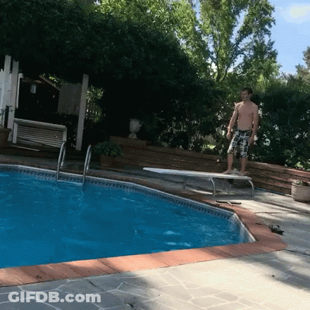 A Man Stands On A Diving Board Near A Pool GIF