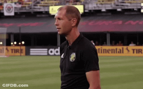 A Man Stands On A Soccer Field In Front Of A Continental Tire Sign GIF