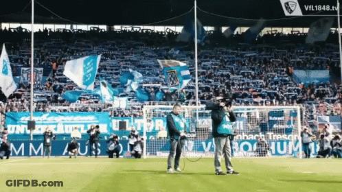 A Man Stands On A Soccer Field In Front Of A Sign That Says Vil1848.tv GIF