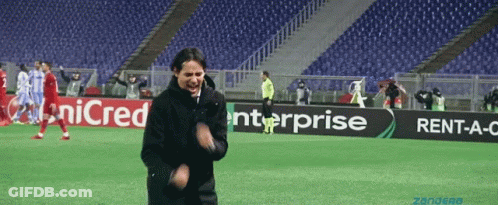 A Man Stands On A Soccer Field In Front Of An Enterprise Ad GIF