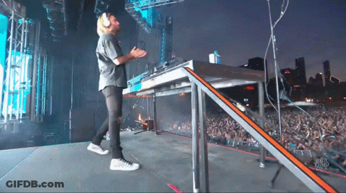 A Man Stands On A Stage In Front Of A Crowd And A Sign That Says ' Chicago Radio ' On It GIF