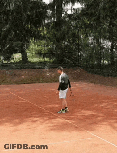 A Man Stands On A Tennis Court Holding A Tennis Racket GIF