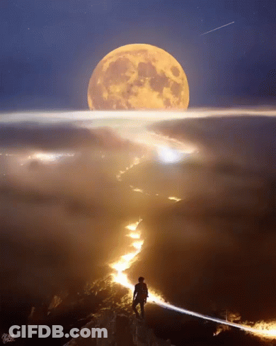 A Man Stands On Top Of A Mountain Looking At The Full Moon GIF