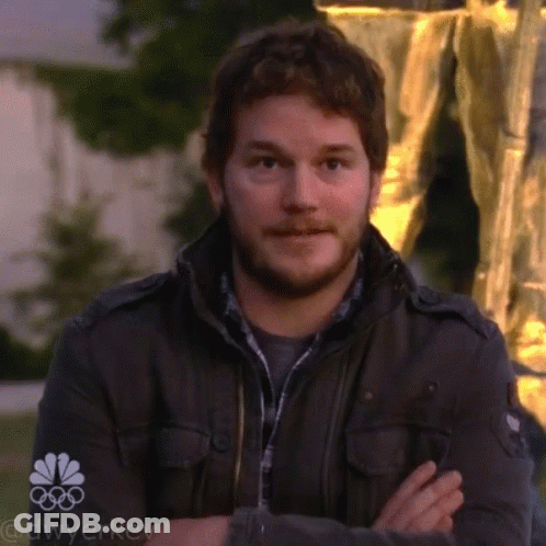 A Man Stands With His Arms Crossed In Front Of A Sign That Says Nbc GIF