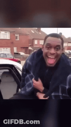 A Man Sticking His Tongue Out While Sitting In The Back Of A Car GIF