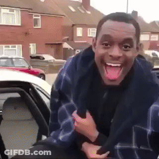 A Man Sticking His Tongue Out While Sitting In The Back Seat Of A Car GIF