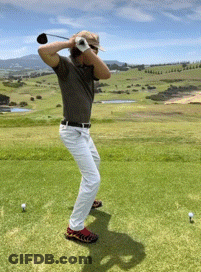A Man Swings A Golf Club At A Golf Ball GIF