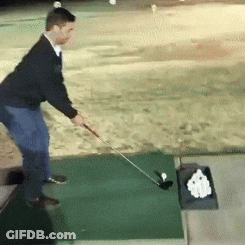 A Man Swings A Golf Club On A Green Mat GIF