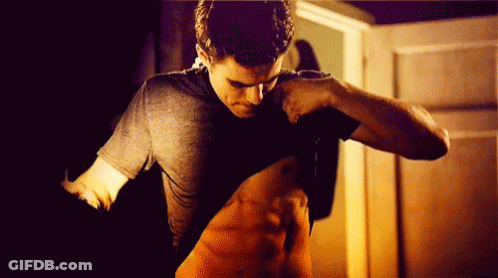 A Man Takes Off His Shirt To Show Off His Muscles GIF