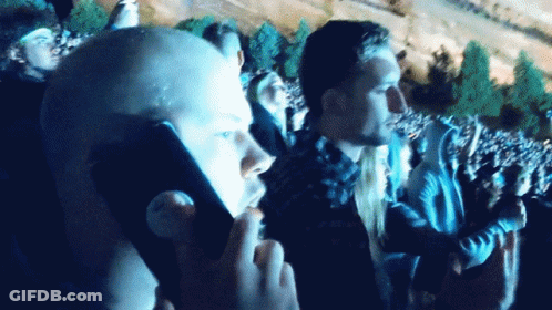 A Man Taking A Picture Of A Crowd With A Cellphone GIF