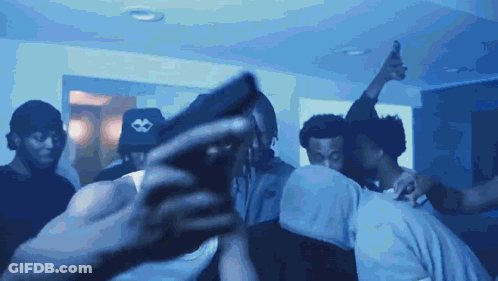 A Man Taking A Picture Of A Group Of People With A Cell Phone GIF