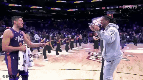 A Man Taking A Picture Of A Player With A Sign That Says Suns Win GIF