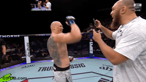 A Man Taking A Picture Of Another Man In A Boxing Ring That Says Espn Live GIF