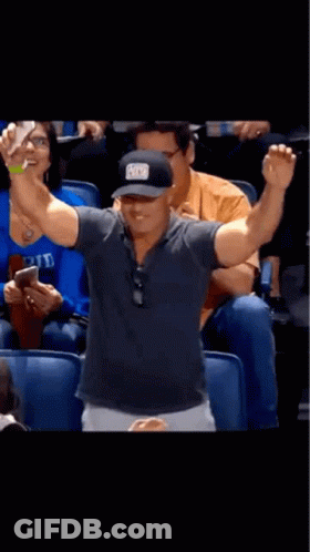 A Man Taking A Picture Of Himself In A Stadium With A Hat That Says ' A ' On It GIF