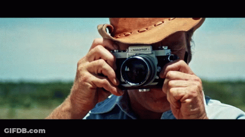 A Man Taking A Picture With A Nikkormat 1 Camera GIF