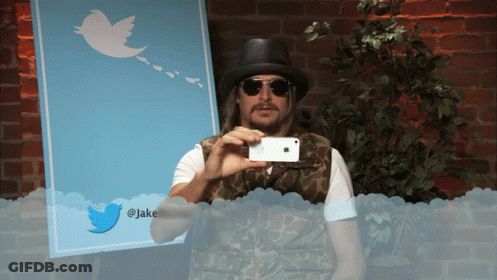 A Man Taking A Picture With A Twitter Icon In The Background GIF
