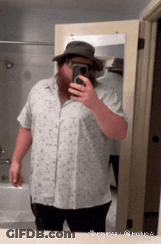 A Man Taking A Selfie In Front Of A Mirror With The Hashtag Minimax On The Bottom Right GIF