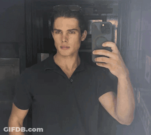 A Man Taking A Selfie With His Phone In A Dark Room GIF