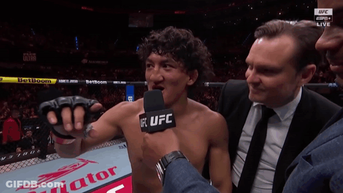 A Man Talking Into A Microphone With The Word Ufc On His Chest GIF